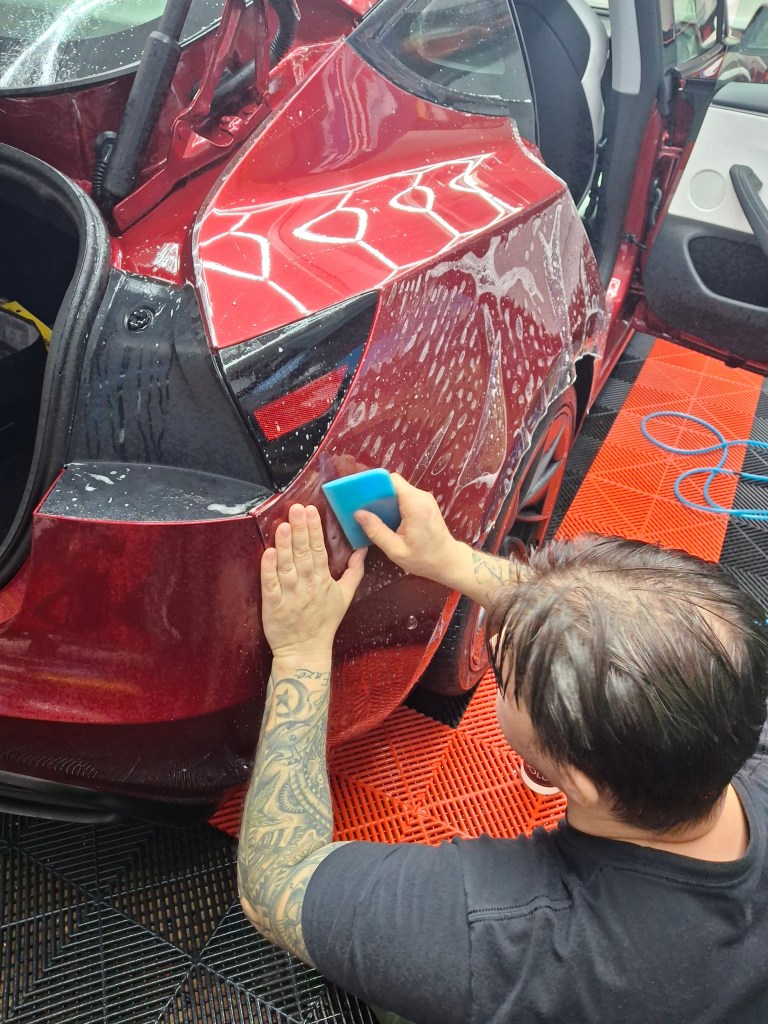 Tesla Model Y receiving a full front XPEL paint protection film installation in Naperville to prevent rock chips.
