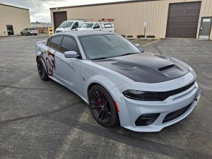 Close-up of 3M certified installers at The Wrench Shack tucking edges for a seamless, paint-like car wrap finish.